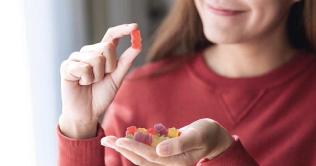 A woman displays a piece of gummy bears, illustrating what to do if your dog ate gummy bears.